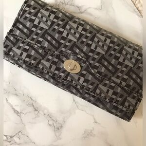 Black and gray patterned wallet with zipped compartment on back of wallet.